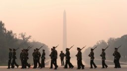 With the Washington Monument in the background and a thick layer of smoke, Marine Corps honor color guard rehearse, June 8, 2023, in Washington.