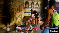 Migrantes se paran cerca de alimentos dañados después de que los migrantes, que intentaban llegar a EEUU, fueran atacados por personas desconocidas mientras se encontraban en un edificio abandonado donde viven, en el centro de Ciudad Juárez, México, el 17 de abril de 2023.