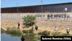 Migrantes se acercan al muro fronterizo entre Ciudad Juárez, México, y El Paso, Texas, horas antes del fin del Título 42, el 11 de mayo de 2023