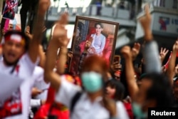 FILE - Protesters hold up a portrait of Aung San Suu Kyi and raise three-finger salutes, during a demonstration to mark the second anniversary of Myanmar's 2021 military coup, outside the Embassy of Myanmar in Bangkok, Thailand, Feb. 1, 2023.