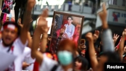 រូបឯកសារ៖ បាតុករ​លើក​រូបថត​របស់​អ្នកស្រី Aung San Suu Kyi និង​លើក​ម្រាមដៃ​បី​ឡើង ក្នុង​អំឡុងពេល​នៃ​ការ​ធ្វើ​ការ​តវ៉ា​នៅ​ក្នុង​គម្រប់​ខួប​ឆ្នាំ​ទី​២​នៃ​ការ​ធ្វើ​រដ្ឋប្រហារ​យោធា​​មីយ៉ាន់ម៉ា​ នៅ​ខាង​ក្រៅ​ស្ថានទូត​មីយ៉ាន់ម៉ា​ក្នុង​ក្រុង​បាងកក ប្រទេស​ថៃ ថ្ងៃទី ១ ខែកុម្ភៈ ឆ្នាំ២០២៣។