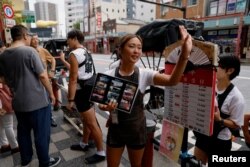 Rickshaw puller Shiori Yoshida, 28, attracts tourists to the guided tour at the Asakusa district in Tokyo, Japan, August 22, 2023.