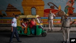 Policemen stop an auto rickshaw at a checkpoint as traffic restrictions and diversions are placed ahead of the weekend's G20 Summit, in New Delhi, Sept. 8, 2023.