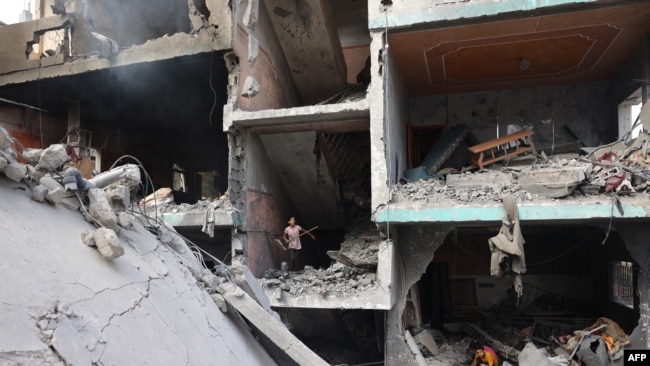 Palestinians children search through the rubble of their home a day after an operation by the Israeli Special Forces in the Nuseirat camp, in the central Gaza Strip on June 9, 2024.