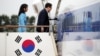 South Korea's President Yoon Suk Yeol, right, and his wife, Kim Keon Hee, board a plane as they leave for Washington at Seoul Air Base in Seongnam on April 24, 2023. 