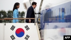 South Korea's President Yoon Suk Yeol, right, and his wife, Kim Keon Hee, board a plane as they leave for Washington at Seoul Air Base in Seongnam on April 24, 2023. 