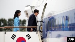 Presiden Korea Selatan Yoon Suk Yeol (kanan) dan ibu negara Kim Keon-hee menaiki pesawat yang akan berangkat menuju Washington di Pangkalan Udara Seoul di Seongnam, pada 24 April 2023. (Foto: Yonhap/AFP)