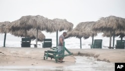 Furniture strewn along Miramar Beach by the winds of Tropical Storm Alberto is recovered, June 20, 2024. The storm weakened Thursday as it moved inland over Mexico.
