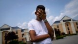 Mohamed, a 19-year-old fleeing political persecution in Mauritania, poses for a photo that obscures his face to protect his identity, outside the Crossroads Hotel, before heading into town for a work opportunity, May 22, 2023, in Newburgh, N.Y. 