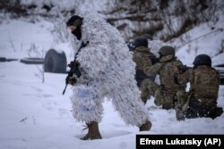 Members of the pro-Ukrainian Russian ethnic Siberian Battalion practice at a military training close to Kyiv, Ukraine, Wednesday, Dec. 13, 2023. (AP Photo/Efrem Lukatsky)