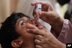 Seorang petugas kesehatan memberikan vaksin polio kepada seorang anak di Karachi, Pakistan, Senin, 23 Mei 2022. (Foto: AP)