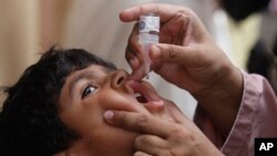 Seorang petugas kesehatan memberikan vaksin polio kepada seorang anak di Karachi, Pakistan, dalam program imunisasi pada23 Mei 2022. (Foto: Fareed Khan)
