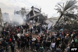 Warga Palestina berkumpul di sekitar rumah keluarga Shehada yang hancur menyusul pengboman Israel terhadap Rafah di Jalur Gaza selatan pada 14 Desember 2023. (Foto: AFP)