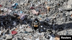 FILE: A man sits on the rubble, in the aftermath of a deadly earthquake in Kahramanmaras, Turkey, where a 17 year old girl was rescued after nearly a week and a half trapped. Taken Feb. 15, 2023. 