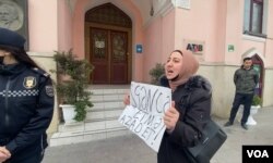 Gulmira Aslanova, whose husband, journalist Polad Aslanov, is serving 13 years in prison, holds a sign saying, 'Don't torture. Free,' during a protest she held in front of the presidential administration building in Baku, Azerbaijan, April 8, 2022. (VOA)