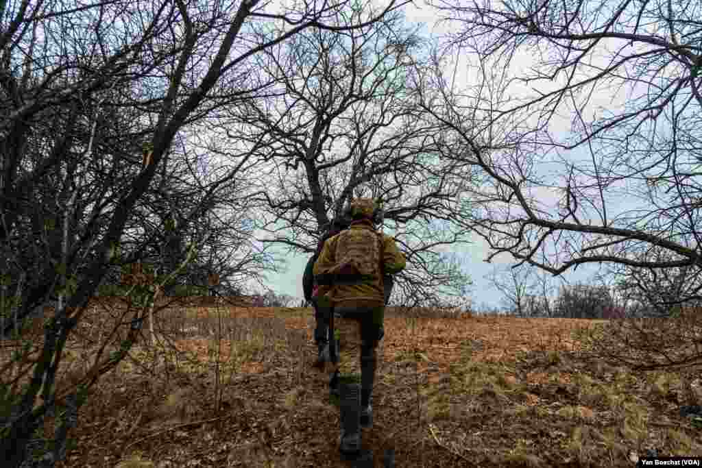 A soldier walks back to his bunker after having the order to fire with his artillery piece canceled by his superiors, in Chasiv Yar, March 5, 2024. With a shortage of ammunition, Ukrainian soldiers are firing 10 times less than a year ago.