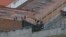 Prisoners stand on the roof of the Turi jail where dozens of prison guards and police officers were kidnapped by inmates in Cuenca, Ecuador, Aug. 31, 2023. Ecuadorian authorities announced Friday the release of the guards and police.
