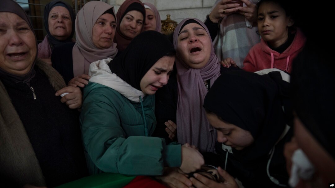 Huda Qatawi memandang wajah putranya, Hazem Qatawi, yang tewas oleh tentara Israel di Beitunia, Tepi Barat, Kamis, 28 Desember 2023. (Foto: Nasser Nasser/AP Photo)