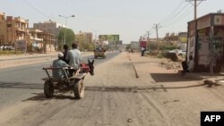 FILE: A man rides his donkey-drawn carriage in southern Khartoum on May 25, 2023. Fighting eased in Sudan, the second full day of a ceasefire that has allowed beleaguered civilians to venture out, even as they await safe aid corridors and escape routes.