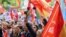 A man holds a rose as people gather outside Spain's Socialist Party headquarters to show support for Prime Minister Pedro Sanchez in Madrid, April 27, 2024. 