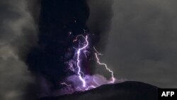 Kilat menyambar di saat Gunung Ibu di Halmahera Barat, Maluku Utara, memuntahkan abu vulkanik ketika erupsi pada 18 Mei 2024. (Foto: AFP/PVMBG)