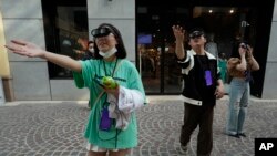 Visitors to a mall touch air as they try out an augmented reality experience of a digital art gala in Beijing, China.