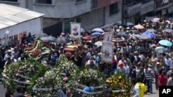 Relatives and friends carry the coffins of four slain men in a funeral procession in Huitzilac, Mexico, May 14, 2024.