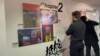 《移英港人—希望与不屈的进行曲》艺术展在利兹市举行，图为英国本地人驻足抵抗(Resist)前，阅读港人的抗争经历。（美国之音 李伯安）