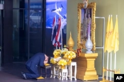 Thailand's former Prime Minister Thaksin Shinawatra prays in front of a portrait of King Maha Vajiralongkorn as he arrives at Don Muang airport in Bangkok, Thailand, Aug. 22, 2023.