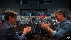 Spanish Prime Minister Pedro Sánchez applauds the socialist candidate Salvador Illa, left, during a campaign rally in Villanova i la Gertru, near Barcelona, Spain, May 9, 2024. 