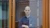 Wartawan Wall Street Journal Evan Gershkovich terlihat berada dalam ruang kaca khusus untuk terdakwa di dalam ruang sidang pada persidangan kasus dugaan spionase yang membelitnya di Yekaterinburg, Rusia, pada 26 Juni 2024. (Foto: Reuters/Evgenia Novozhenina)