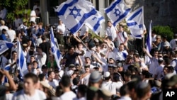 With some of them chanting “Death to Arabs”, Israelis wave national flags during a march marking Jerusalem Day, an Israeli holiday celebrating the capture of east Jerusalem in the 1967 Mideast war, in front of the Damascus Gate of Jerusalem's Old City, June 5, 2024.