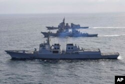 FILE - In this photo provided by South Korea Defense Ministry, destroyers from South Korea, bottom, the U.S., middle, and Japan sail during a joint missile defense drill in international waters off the east coast of Korean peninsula, April 17, 2023.