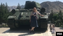 A tourist poses in front of the World War II-era T-34 Soviet tank in Aravan, Osh province, July 7, 2024.