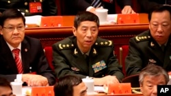 资料照片 -中国新任国防部长李尚福（中）。2017年10月18日，时任中央军委装备发展部部长时出席中共19大开幕式。（美联社照片）