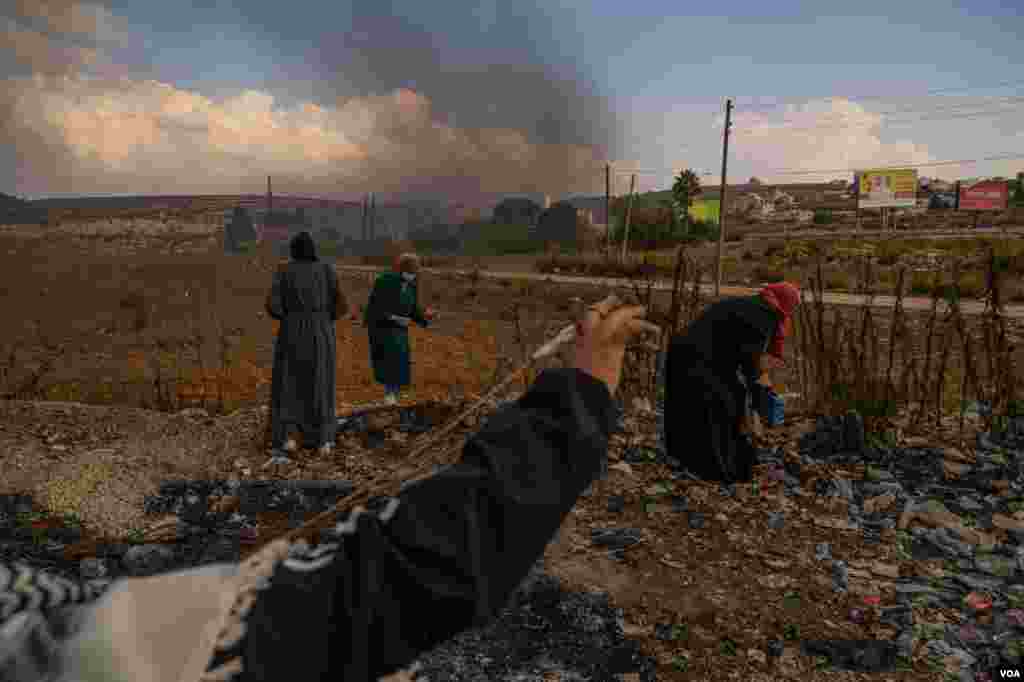 Palestinian girls collect rocks to throw at Israeli soldiers on the outskirts of Ramallah, in the West Bank, Oct. 18, 2023. (Yan Boechat/VOA)