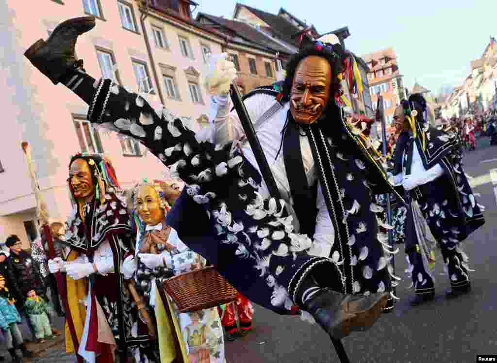 Seorang pengunjung karnaval melompat selama prosesi cerita rakyat tradisional &quot;Narrensprung&quot; (Lompatan Bodoh) sebagai bagian dari perayaan karnaval tahunan di kota Rottweil, Jerman.