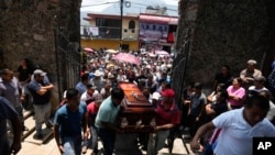 Relatives and friends carry the coffin of a man slain in a mass shooting, in Huitzilac, Mexico, May 14, 2024. 