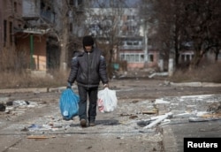 FILE - A resident walks on an empty street in the front line city of Bakhmut, Ukraine, as Russia's attack on Ukraine continues, March 3, 2023.