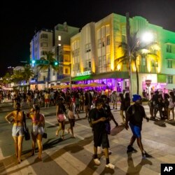 Crowds walk up and down Ocean Drive during spring break in Miami Beach, Fla., March 18, 2023.
