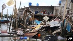 Una casa que se derrumbó sobre el agua después de un terremoto se ve en Puerto Bolívar, Ecuador, el domingo 19 de marzo de 2023.