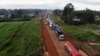 FILE - Parked trucks wait in a 10km queue, to cross the Kenyan-Ugandan border from the town of Busia, Kenya November 14, 2020.