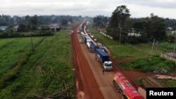 FILE - Parked trucks wait in a 10km queue, to cross the Kenyan-Ugandan border from the town of Busia, Kenya November 14, 2020.