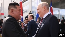 Ruski predsednik Vladimir Putin i severnokorejski lider Kim Džong Un rukuju se tokom susreta u kosmodromu Vostočni, u regionu Amur, na dalekom istoku Rusije,13. septembra 2023.