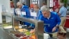 IOC President Thomas Bach tries food from a salad bar while touring the Olympic Village ahead of the 2024 Summer Olympics, July 22, 2024, in Paris, France. 