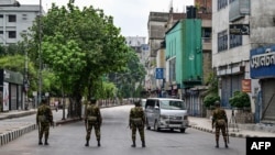 Bangladesh soldiers stand guard along the street following a curfew and the deployment of military forces in Dhaka on July 20, 2024, after days of clashes during protests against government job quotas across the country.