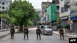 FILE - Bangladesh soldiers stand guard along the street in Dhaka on July 20, 2024, after days of protests against government job quotas across the country. Journalists report being harassed, forced to delete images from their cameras, and injured while covering the unrest.