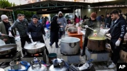 Sejumlah relawan menyiapkan makanan untuk para warga Suriah korban gempa yang mengungsi di Antakya, Turki, pada 10 Februari 2023. (Foto: AP/Hussein Malla)
