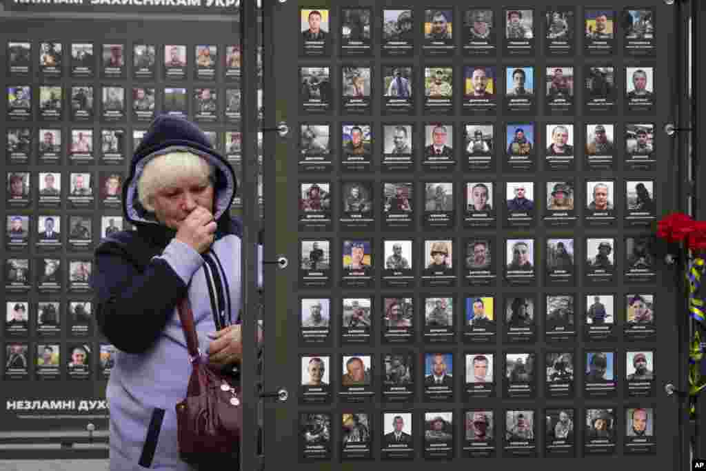 Liudmila Melnik wipes tears as she looks at a photo of her husband Oleksandr, who was killed in a battle with the Russian troops, near the City Hall in Kyiv, Ukraine. &nbsp;(AP Photo/Efrem Lukatsky)
