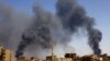 FILE: A man walks while smoke rises above buildings after aerial bombardment, during clashes between the paramilitary Rapid Support Forces and the army in Khartoum North, Sudan, May 1, 2023. 